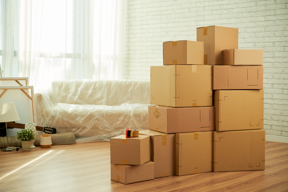 shot room interior with package boxes standing middle sofa-covered with film