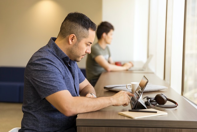 man typing in ipad on desk